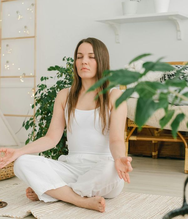 A person in a simple yoga pose in a comfortable home environment.